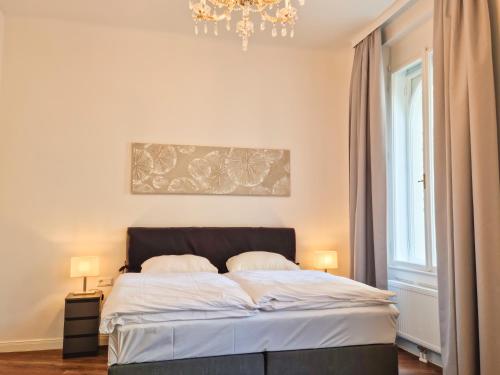 um quarto com uma cama e um lustre em Pension Mozart - Newly Renovated em Viena