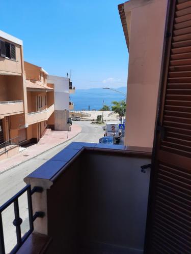 einen Balkon mit Blick auf eine Straße und das Meer in der Unterkunft Bed and Breakfast Cala Luna in Castelsardo