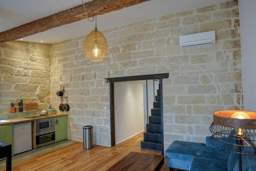 un soggiorno con una parete in pietra e una porta di Le petit Corum - HH a Montpellier