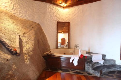 a bathroom with a bath tub and a mirror at Chauve Souris Relais in Anse Volbert Village