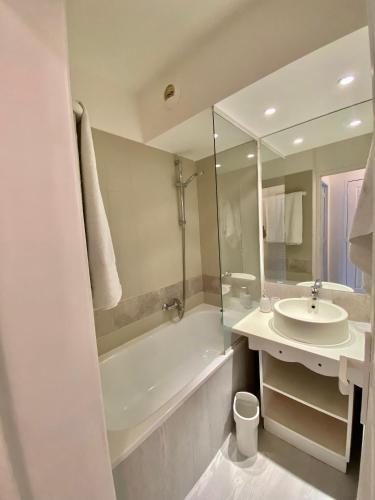 une salle de bain avec un lavabo et une baignoire et un lavabo dans l'établissement La suite new-yorkaise Disneyland Paris, à Serris