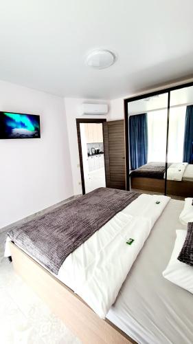 a large white bed in a room with windows at BUGAZ GOLD апартаменти біля моря in Karolino-Buhaz