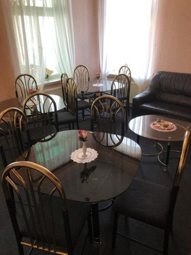 a living room with a table and chairs at Pension „La Rose“ in Norden