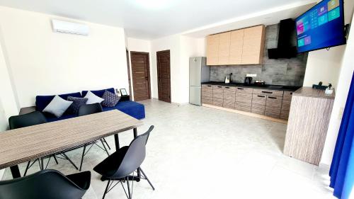 eine Küche und ein Wohnzimmer mit einem Tisch und Stühlen in der Unterkunft BUGAZ GOLD апартаменти біля моря in Karolino-Buhas