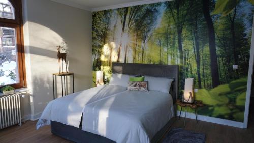 ein Schlafzimmer mit einem Bett mit einem großen Gemälde an der Wand in der Unterkunft Ferienhaus Vier Jahreszeiten in Bad Sachsa