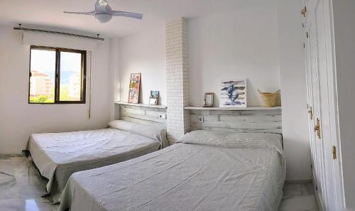 a bedroom with two beds and a ceiling fan at Salobreña - Primera Línea de Playa junto al Paseo Marítimo in Salobreña