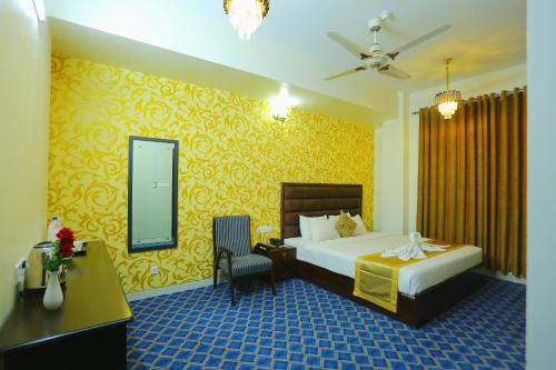 a bedroom with a bed and a desk and a mirror at Grand Mostafa Hotel Ababil in Sylhet
