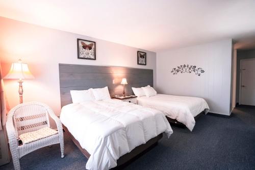 a hotel room with two beds and a chair at Scenic Inn in Conway