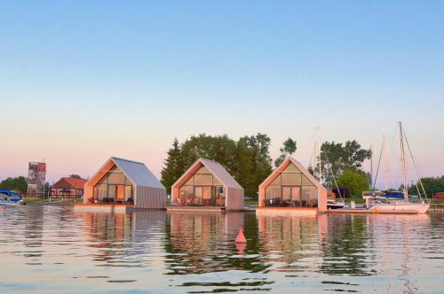 a group of three houses in the water at Domy na Wodzie na Mazurach in Pisz