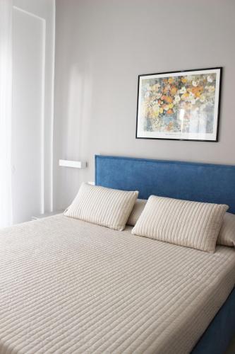 a bed with a blue headboard and two pillows at Casa Thalassa in Cefalù
