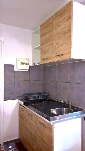 une cuisine avec une cuisinière et un évier dans l'établissement Logement climatisé avec jardin et parking pour 2 personnes en bord de plage, à La Ciotat