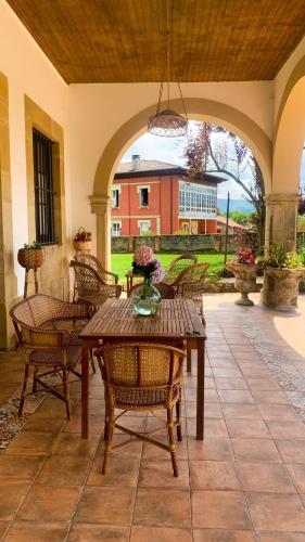 a patio with a wooden table and chairs at La Venta de Miyares - Casa de Indianos in Piloña