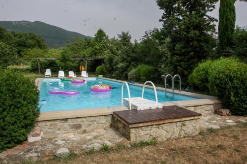 a pool with a pool table and chairs on top of it at Terra della Lanterna in Cetona