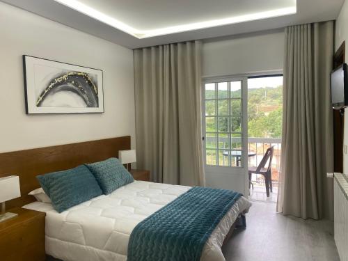 een hotelkamer met een bed en een balkon bij Ze Luis in Chaves