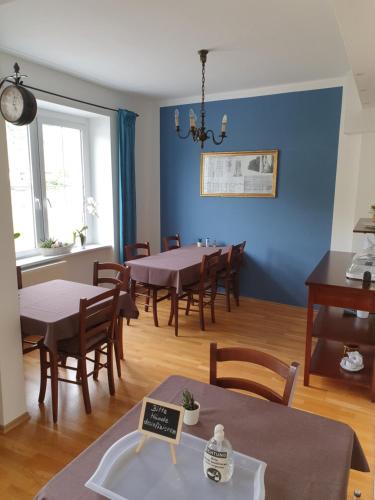 une salle à manger avec des murs bleus, des tables et des chaises dans l'établissement Haus Burgfrieden Cochem, à Cochem