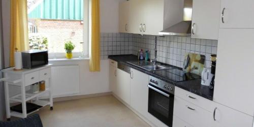 a kitchen with white cabinets and a sink and a window at Zimmer 4 + 5 zusammen gemietet ein Apartment in Bachenbrock