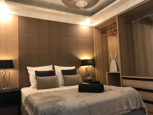 une chambre avec un grand lit et deux lampes dans l'établissement LAZARE Maison de Maître , appartements de standing avec parking privatif à seulement 7 minutes à pied du centre historique de Béziers, à Béziers