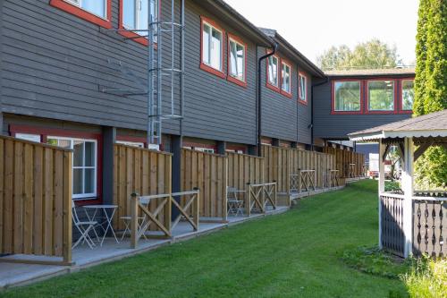 a building with chairs and a fence next to a yard at Gylle Hotell & Restaurang Brödernas in Borlänge