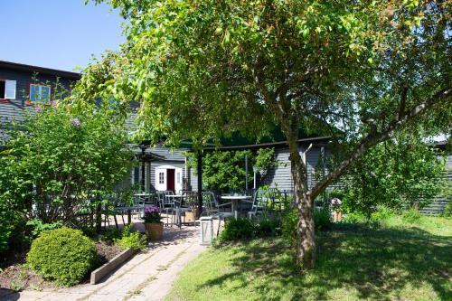 a house with a tree and a table and chairs at Gylle Hotell & Restaurang Brödernas in Borlänge
