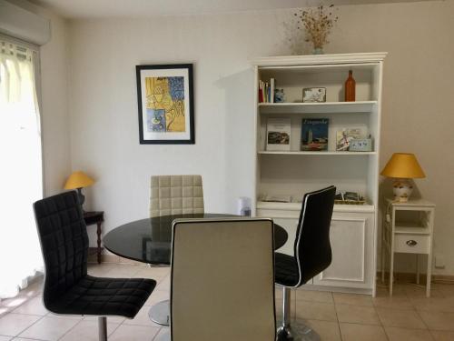 une salle à manger avec une table et des chaises en verre dans l'établissement Les Capucins, à Carcassonne