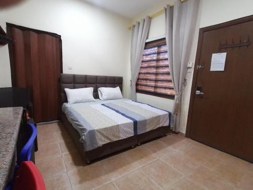 a small bedroom with a bed and a window at Relax House For Studio Rooms Apartment in Aqaba