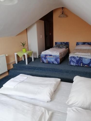 a room with two beds and a table at Flamingó Étterem Szálláshely in Somlójenő