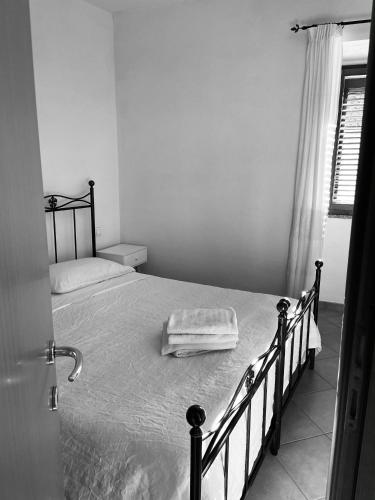 a black and white photo of a bed in a bedroom at Sa domo de su re in Torralba