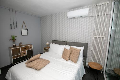 1 dormitorio con 1 cama con sábanas y almohadas blancas en Castiello B&B en Roquebrune-Cap-Martin