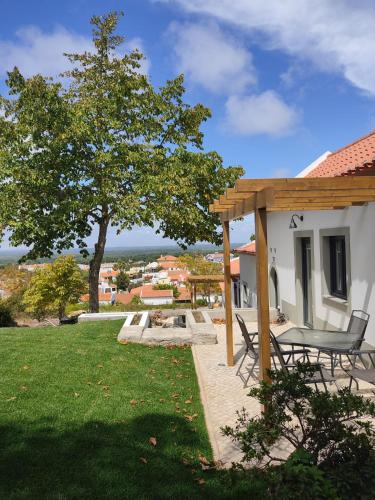 a patio with a table and a tree at Villa Vista in Sesimbra