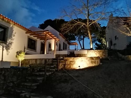 a house with a stone retaining wall in front of it at Villa Vista in Sesimbra