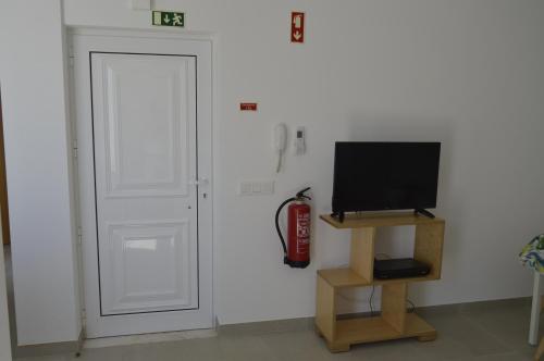 a room with a door and a television and a fire hydrant at Casas da Nespereira, V1 a 350 mtrs. praia in Vila Nova De Cacela
