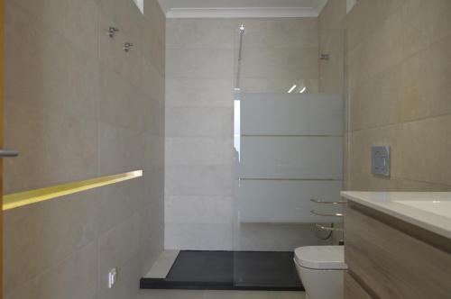 a bathroom with a shower and a toilet and a sink at Casas da Nespereira, V1 a 350 mtrs. praia in Vila Nova De Cacela