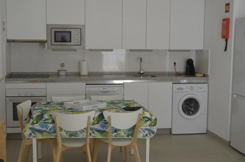 a kitchen with a table with chairs and a sink at Casas da Nespereira, V1 a 350 mtrs. praia in Vila Nova De Cacela