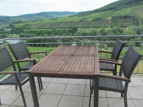 uma mesa de madeira e cadeiras numa varanda com vista em Pension Simon em Reil