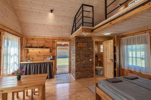 a bedroom in a log cabin with a bed and a desk at Dzintarmājas in Pāvilosta
