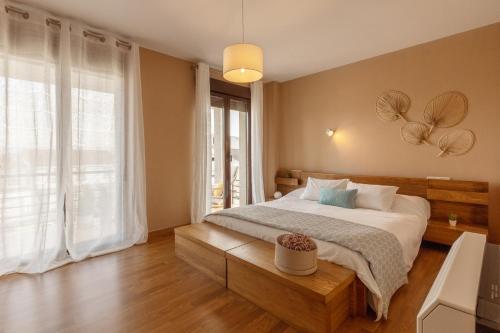 a bedroom with a bed and a large window at Casa Clara in Isla de Arosa