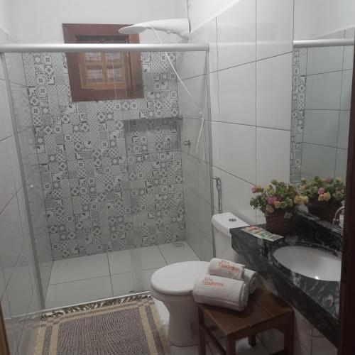 a bathroom with a shower and a toilet and a sink at Pousada Campestre Vila Tiradentes in Tiradentes