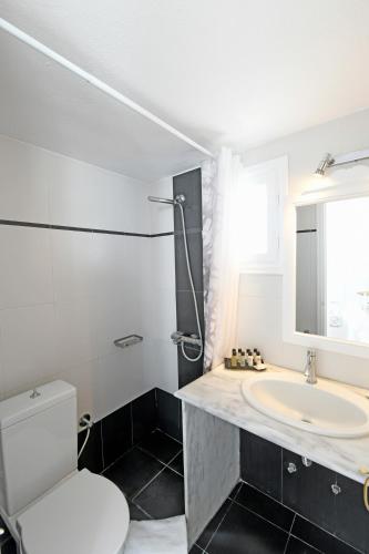 a bathroom with a white toilet and a sink at Casa Bianca in Imerovigli