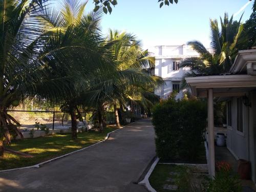 een straat met palmbomen voor een huis bij Kendall place Apartments in Cagayan de Oro
