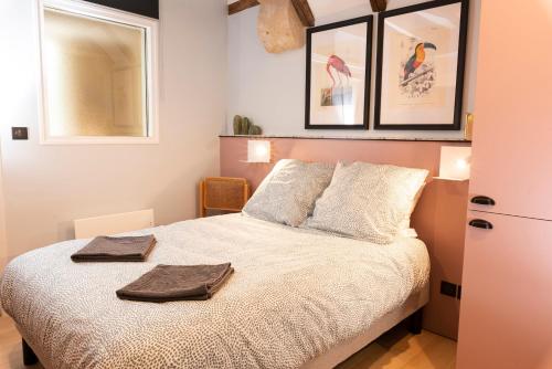 a bedroom with a bed with two towels on it at La Lirosane, 3 studios, 3,7km du Zoo, Centre-ville in Saint-Aignan