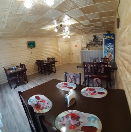 uma sala de jantar com mesa e cadeiras com pratos em Затишні Карпати)) em Verkhovyna