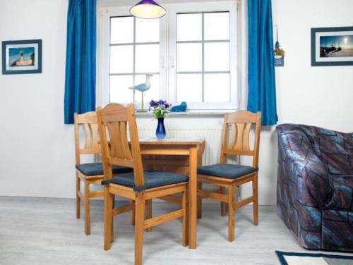 uma mesa de jantar com duas cadeiras e um sofá em Wolkenlos em Insel Poel