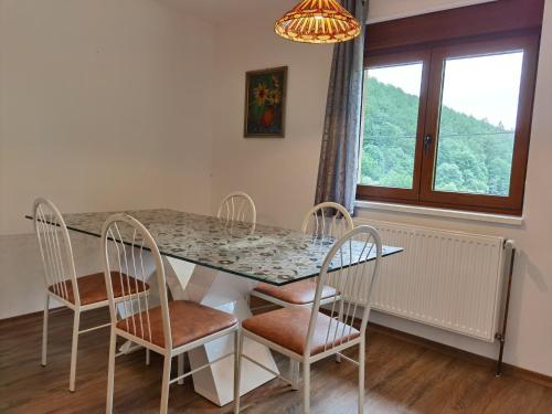 comedor con mesa, sillas y ventana en Gîte Saint Ludan, en Rombach-le-Franc
