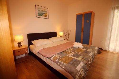 1 dormitorio con 1 cama y mesita de noche con 2 lámparas en Apartment Teo & Leon, en Novi Vinodolski