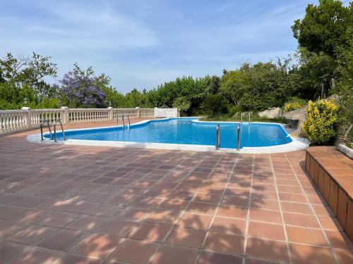 una piscina en un patio con una valla y árboles en La casa azul, en Xàtiva