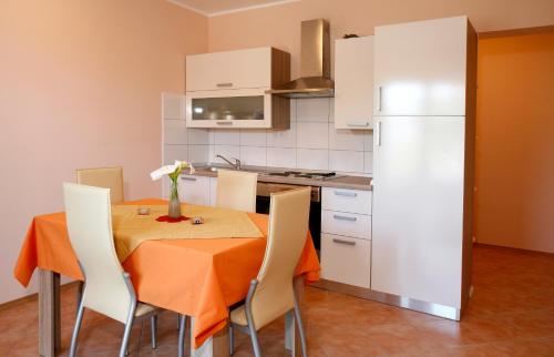 uma cozinha com uma mesa com cadeiras e um frigorífico branco em Apartment Fila i Jure em Solin