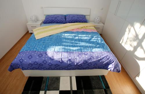 a small bedroom with a bed with purple sheets at Apartment Fila i Jure in Solin