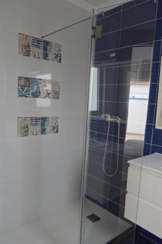 a bathroom with a shower with blue tiles at Moradia V2 nova e próximo da praia in Vila Nova De Cacela