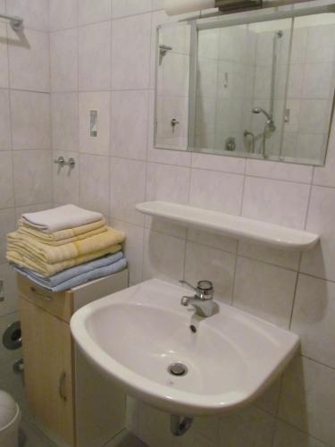 a white bathroom with a sink and a mirror at Ferienwohnung Simon in Reil