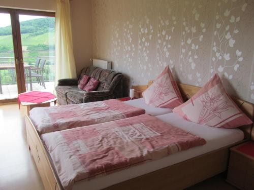a bedroom with a bed with pink sheets and a couch at Ferienwohnung Simon in Reil